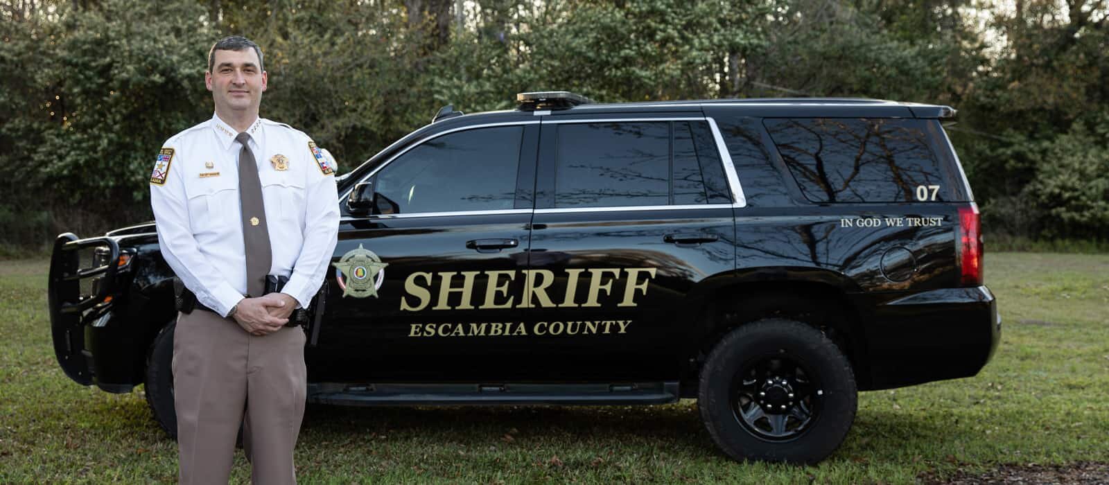 Sheriff Heath Jackson standing next to his sheriff's vehicle.